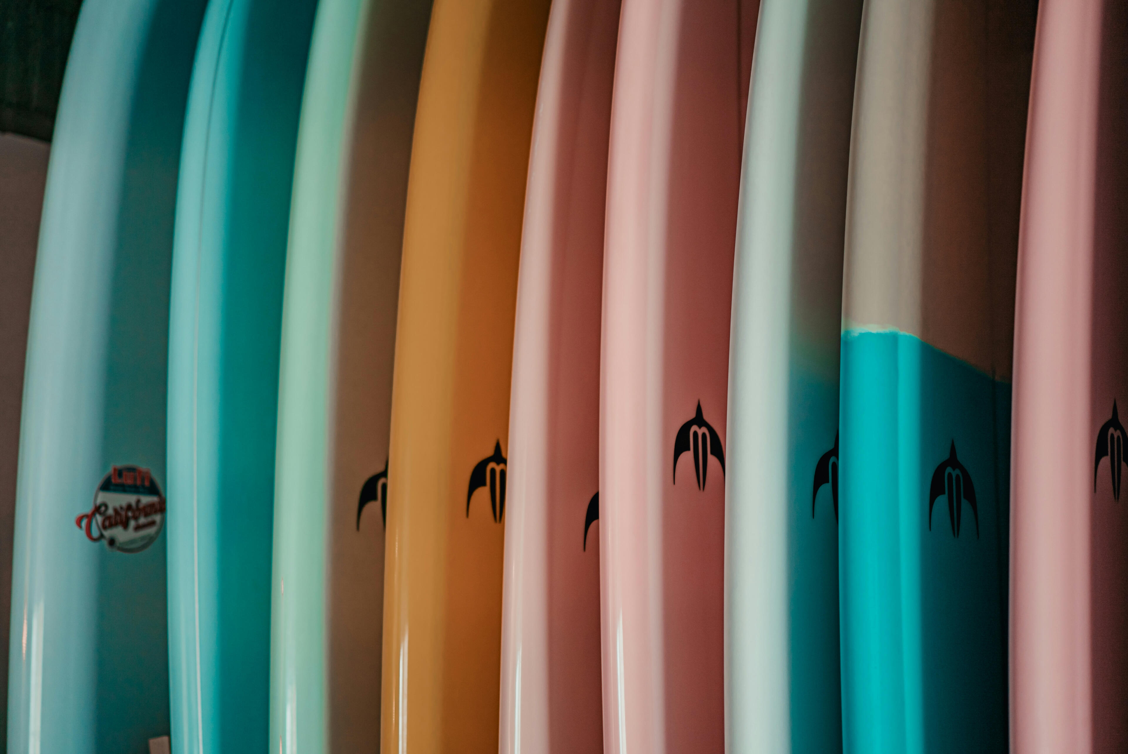 colorful surfboards lined up on rack colorful surfboards lined up on rack