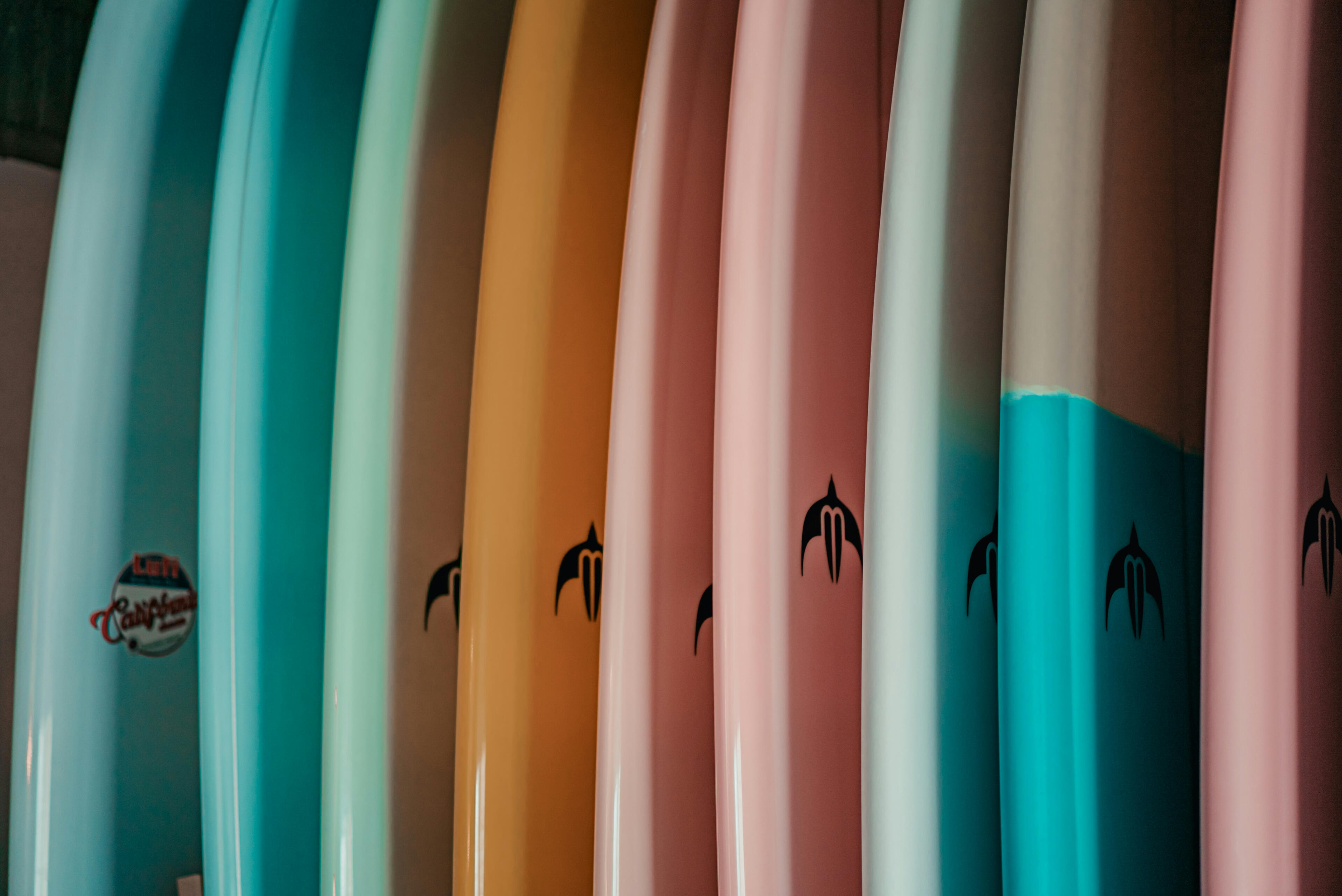 colorful surfboards lined up on rack colorful surfboards lined up on rack